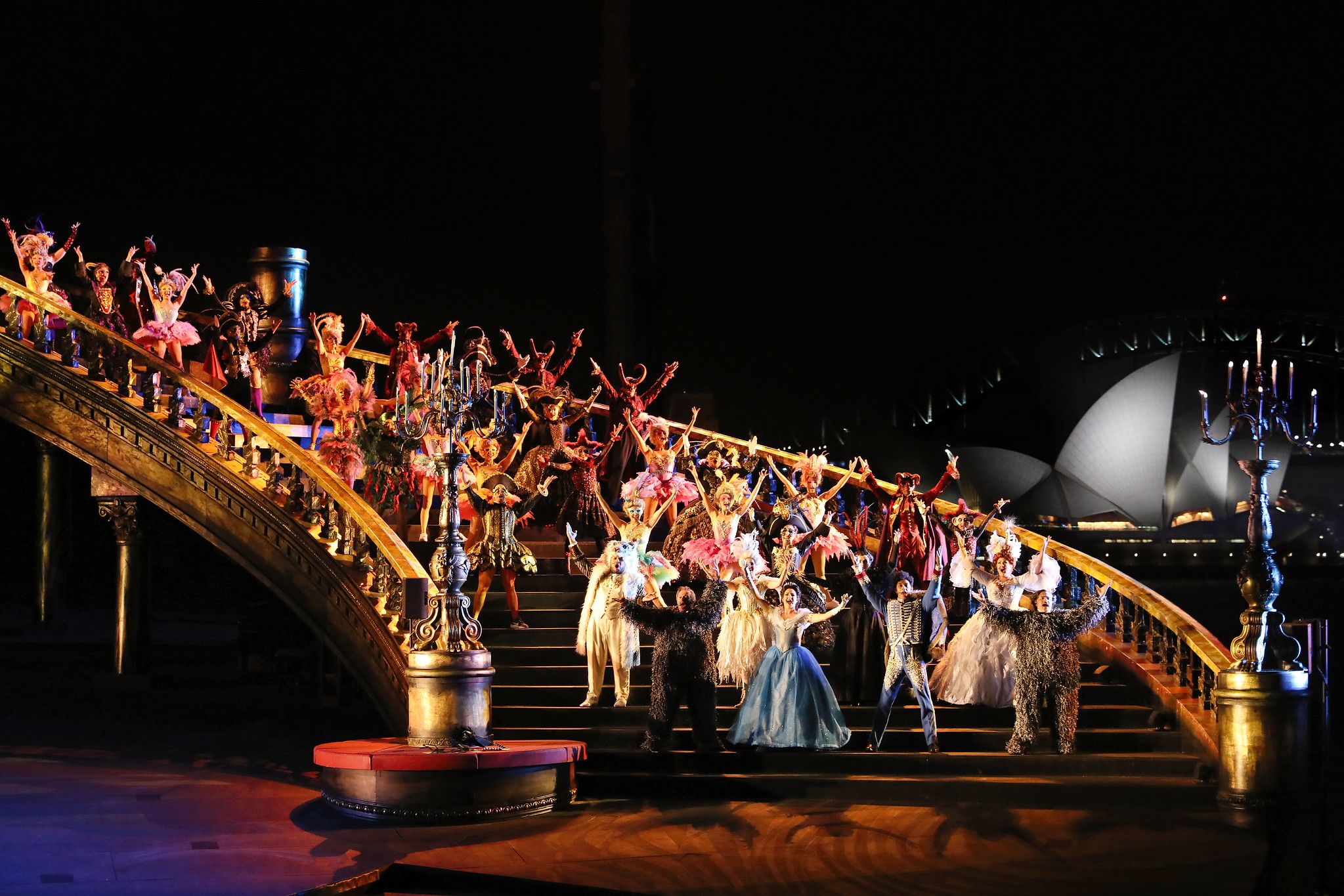 Performers on a giant staircase during the 'Masquerade' scene of The Phantom of the Opera on Sydney Harbour.