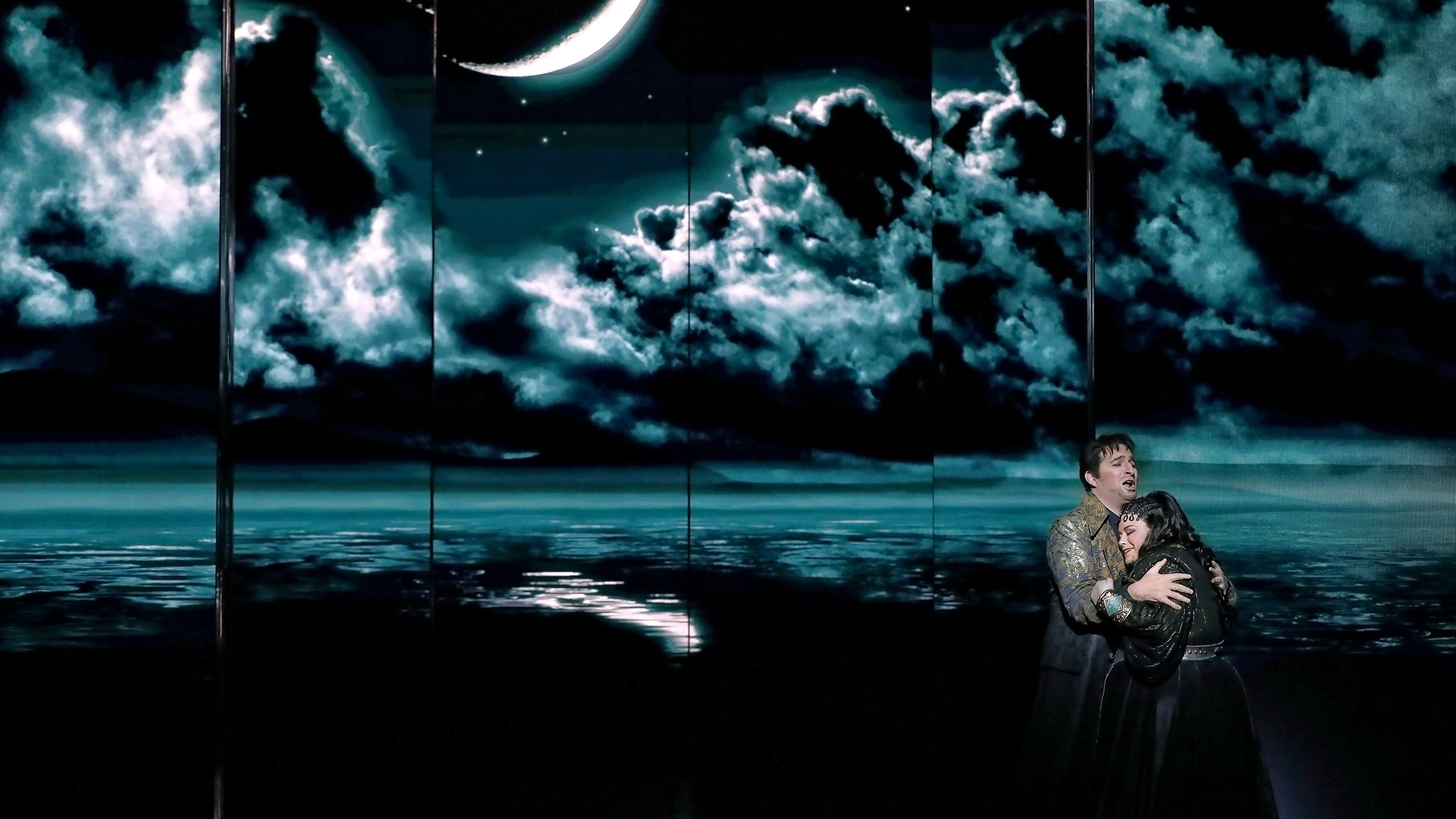 Riccardo Massi as Radamès and Amber Wagner as Aida hugging in a scene in the opera Aida.