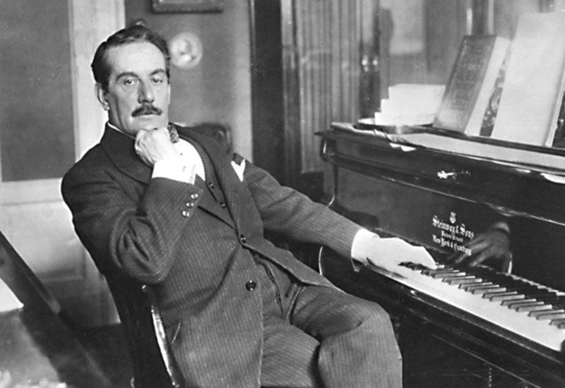Italian composer Giacomo Puccini sitting at his piano.