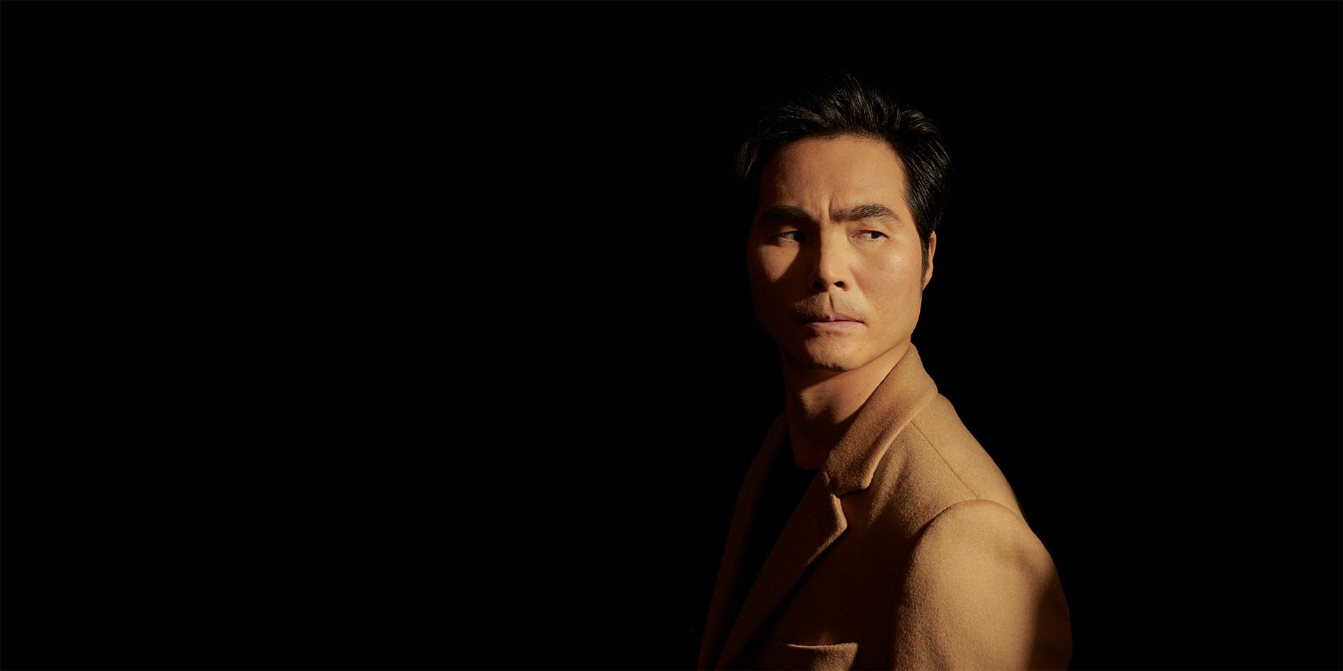 Singer Yonghoon Lee in front of a black background.