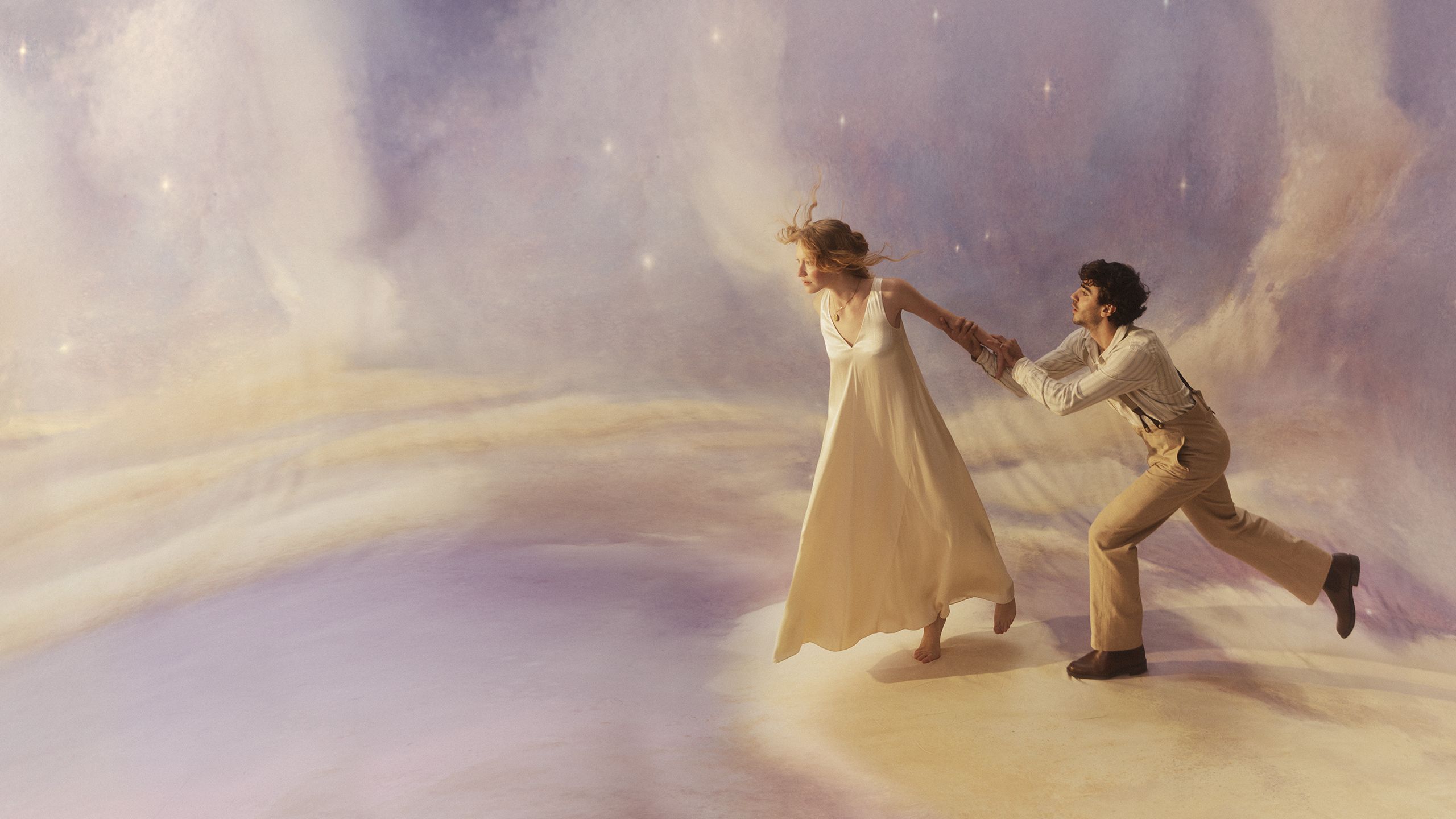 A man and a woman stand atop a canvas painted like a dusky sky. She looks to be leaping or falling off a cloud, while he tries to pull her back.