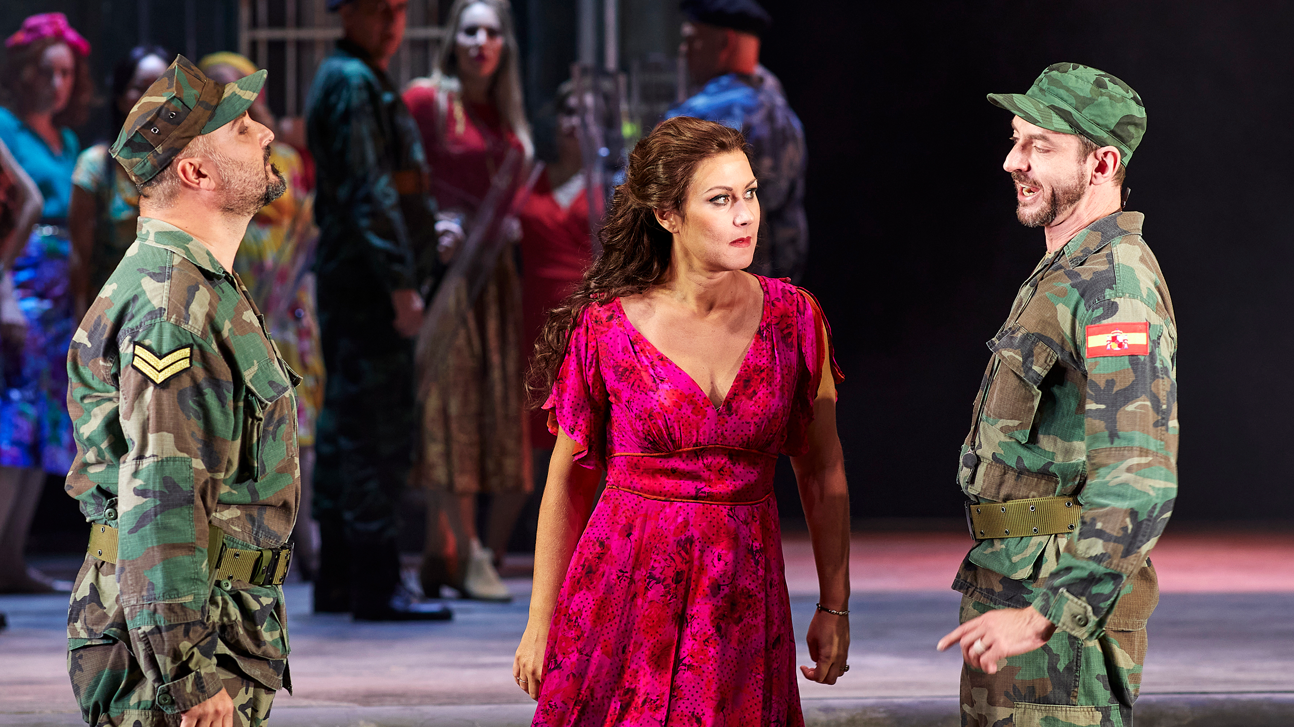 Singer Veronica Simeoni on stage in a red dress as Carmen in the opera Carmen.