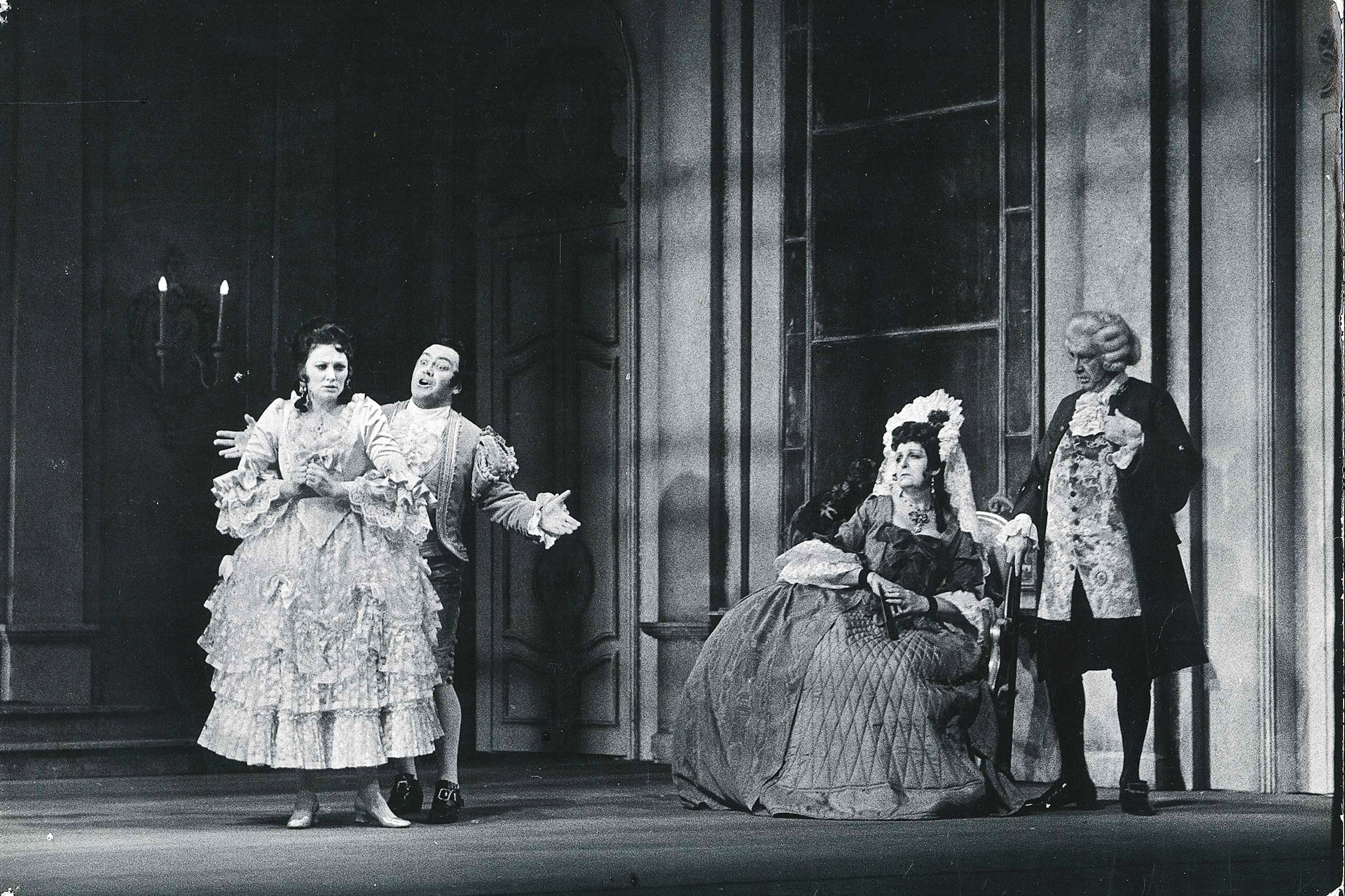 Four people in period costume stand in a comedic pose in a performance of The Marriage of Figaro